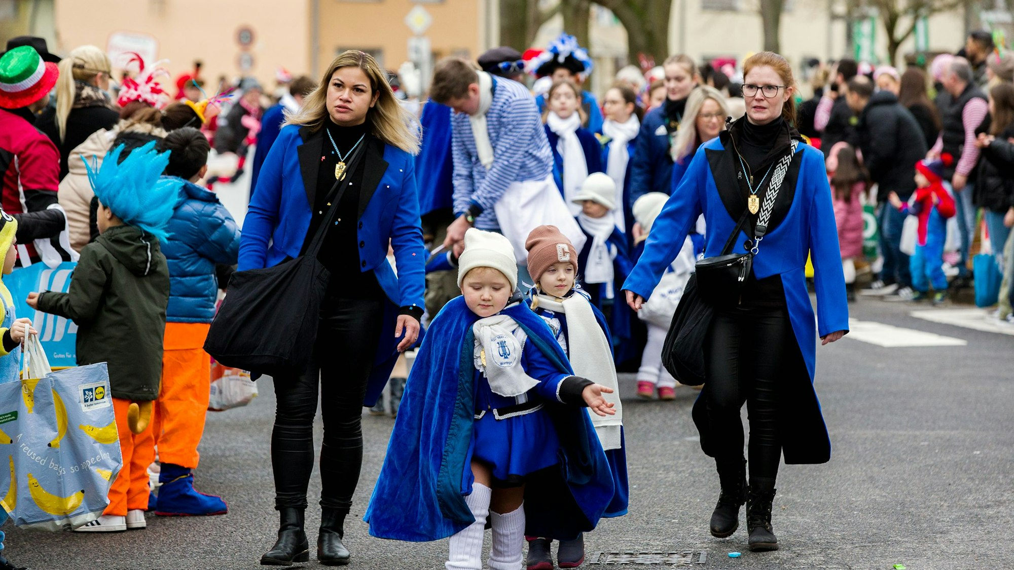 Kinder und Erwachsene laufen auf dem Worringen Kinderkarnevalsumzug mit.