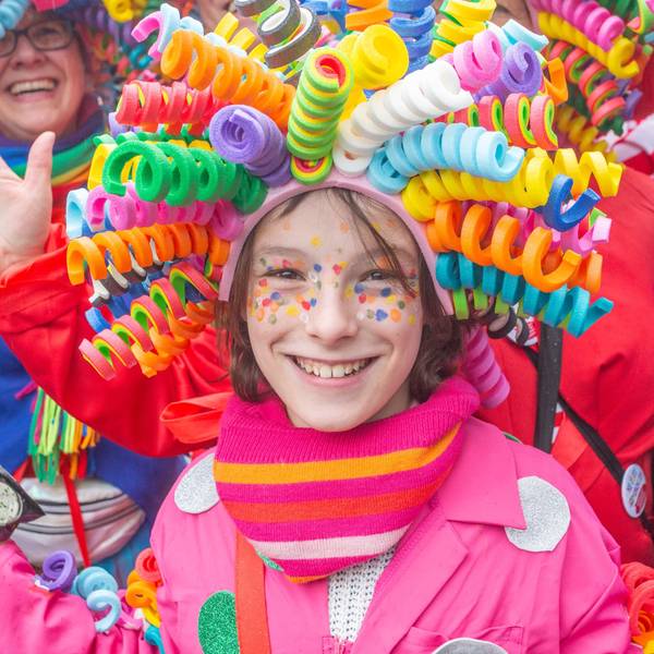 Ein Mädchen trägt eine bunte Perücke auf dem Kopf.