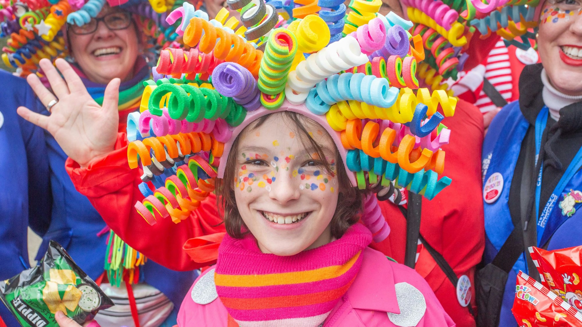 Ein Mädchen trägt eine bunte Perücke auf dem Kopf.