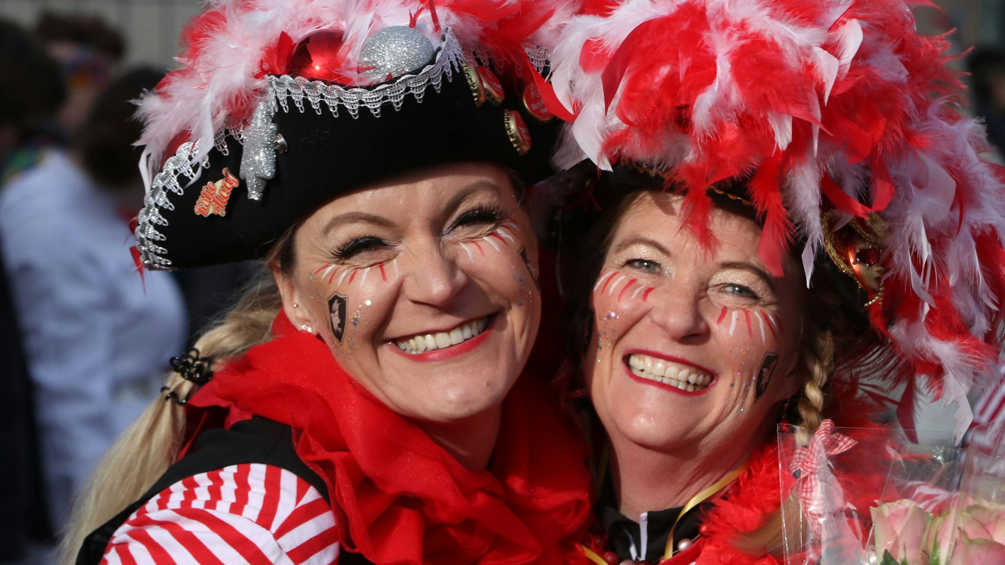 Auf dem Bild sind rot-weiß kostümierte Jecken zu sehen.