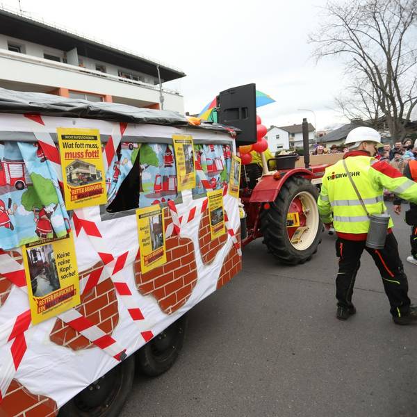 Ein Karnevalswagen mit Fotos und Schildern, auf denen die Feuerwehr die misslichen Zustände im Gerätehaus deutlich macht.