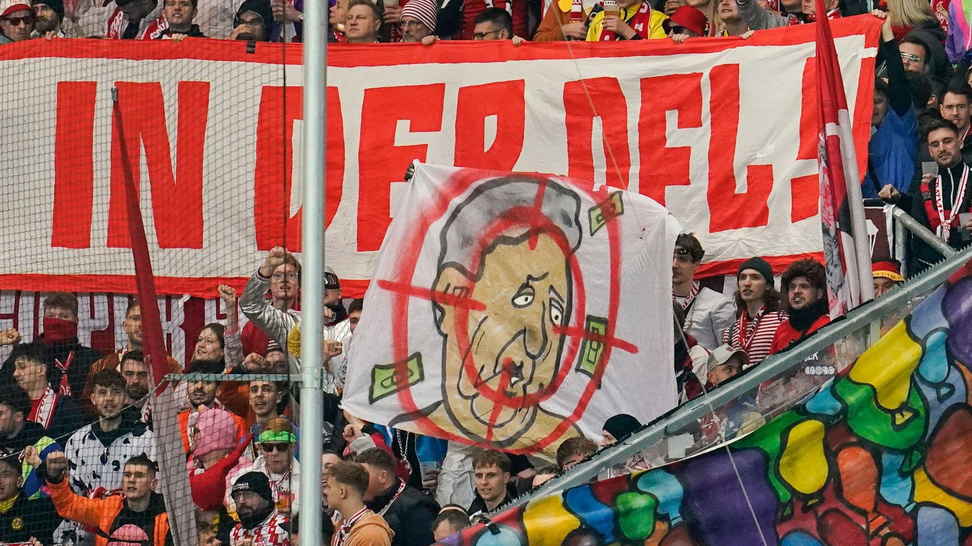 Kölns Fans halten Transparente in die Höhe mit der Aufschrift: „Nein zu Investoren in DFL!“. Darunter ein Schmäh-Plakat gegen Dietmar Hopp.
