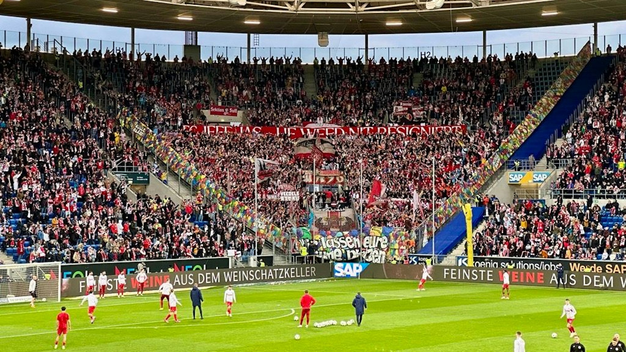 Fans des 1. FC Köln feiern in Hoffenheim mit Bannern und Karnvals-Stimmung