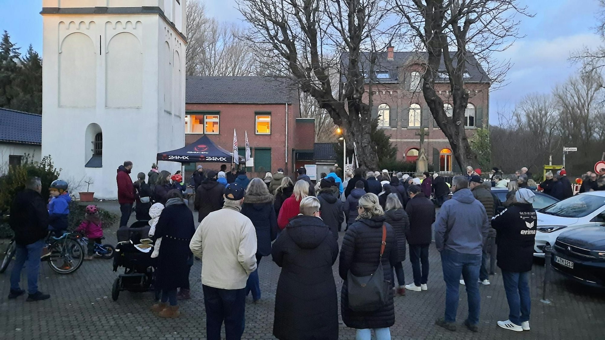 Auf einem Marktplatz stehen einige Menschen.