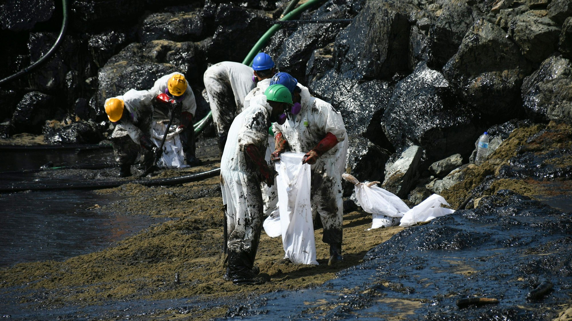 Arbeiter beseitigen einen Ölteppich, der den Strand von Rockly Bay in Scarborough im Südwesten Tobagos erreicht hat.