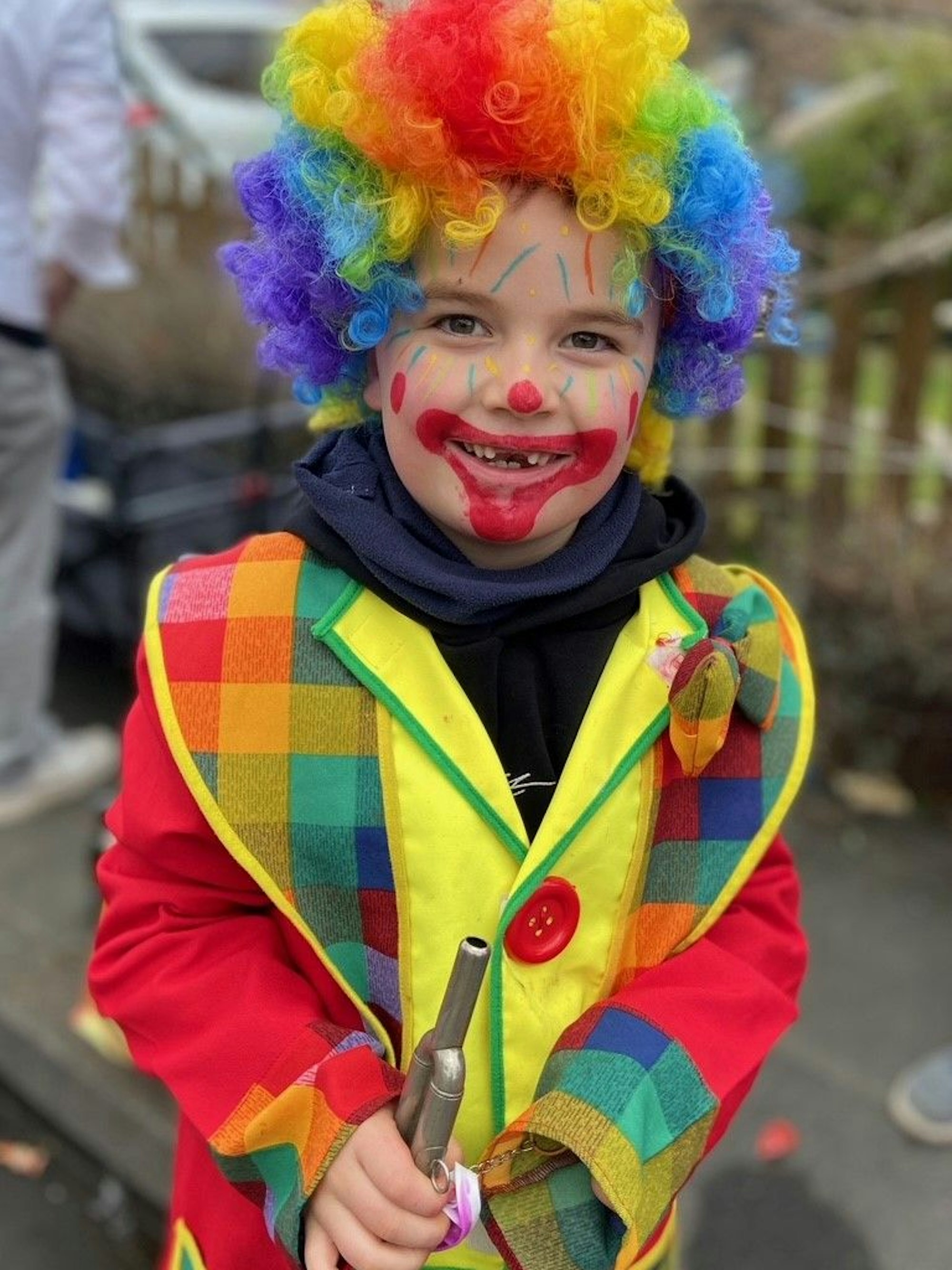 Auf dem Bild ist ein Junge im Clownskostüm zu sehen.