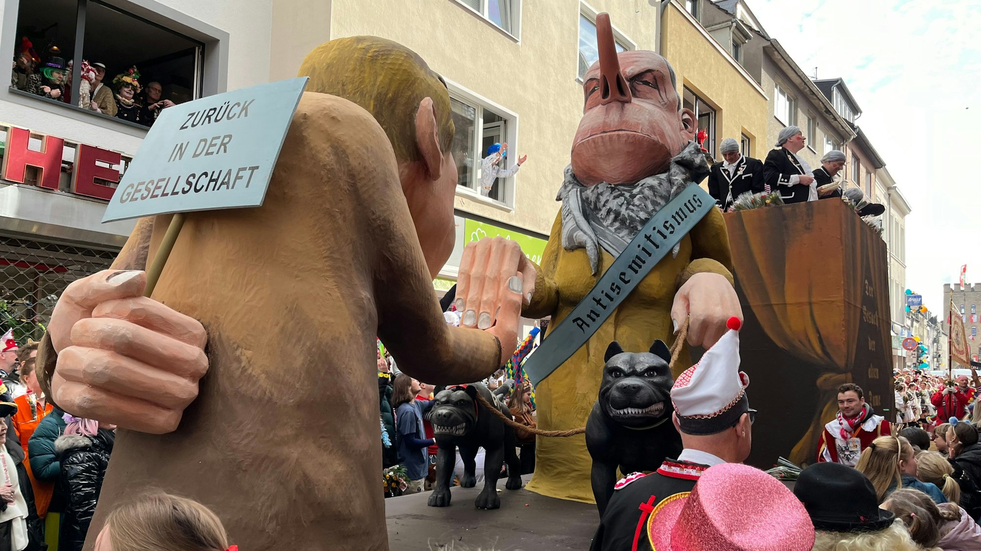 Umstrittenes Motiv auf dem Kölner Rosenmontagszug 2024: Ein Vertreter der neuen Rechten hofiert eine Frau, die durch ihr Halstuch als Palästinenserin charakterisiert ist.