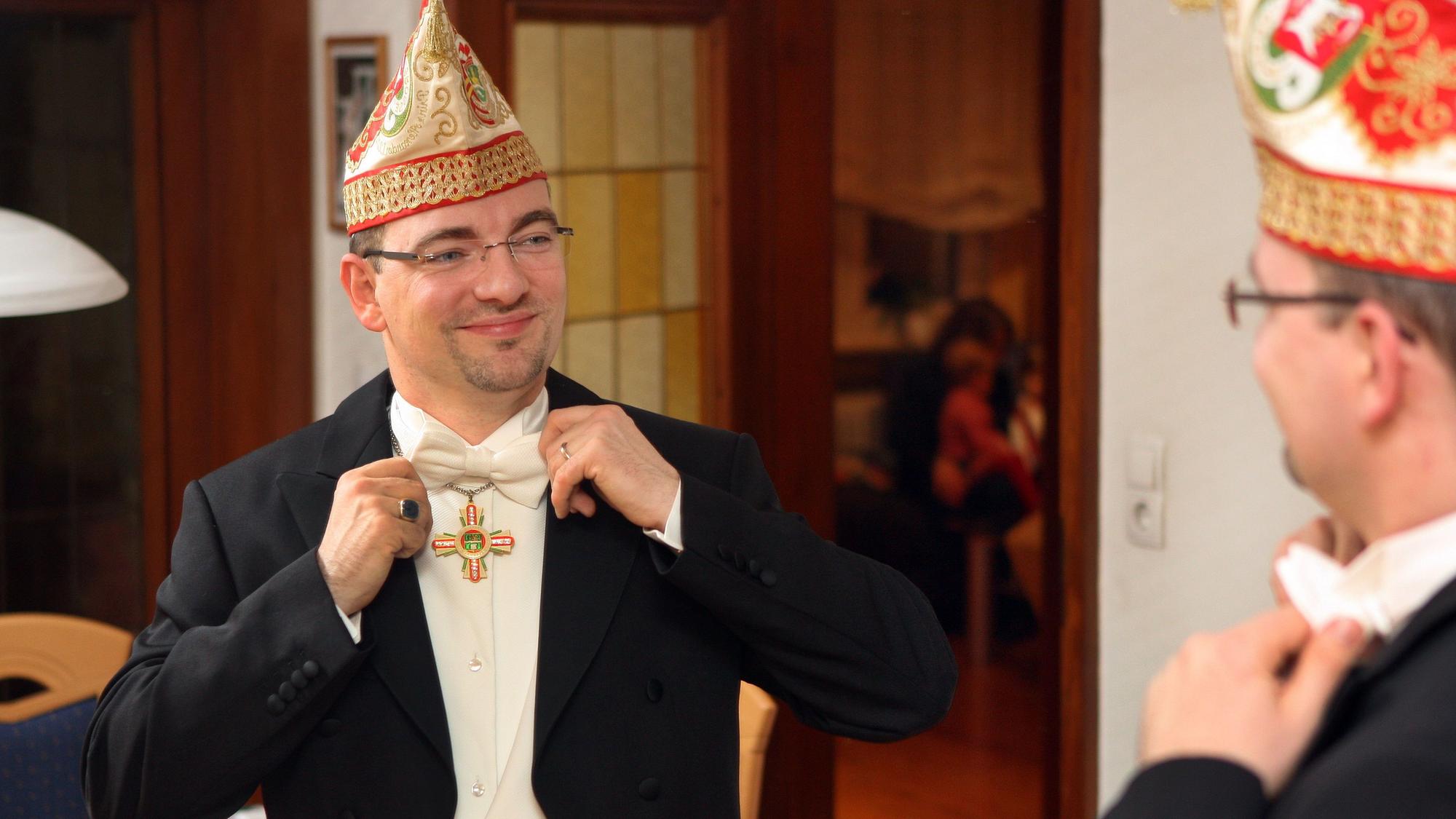 Alexander Pfister steht 2014 vor dem Spiegel und bindet seine Fliege.