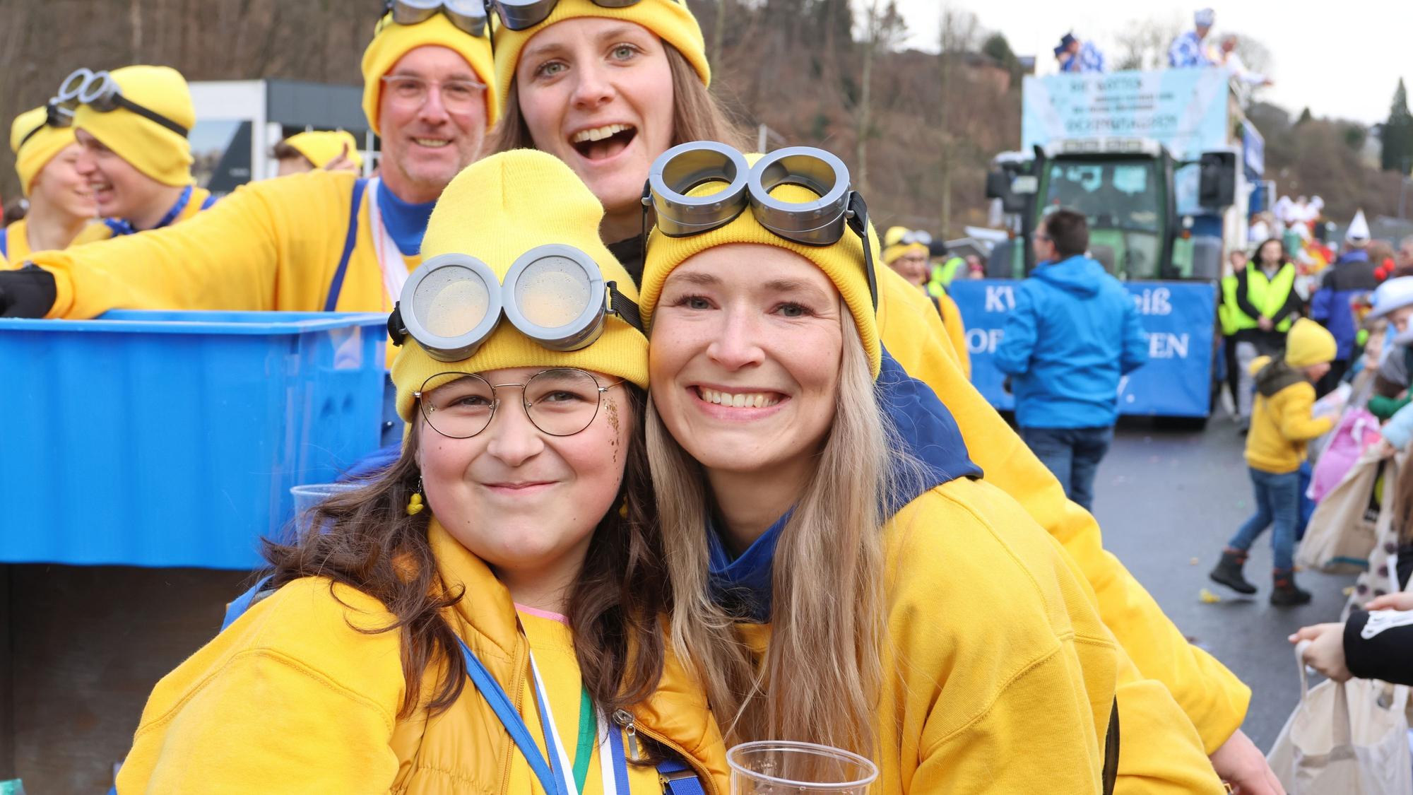 Zwei junge Frauen mit dicken Brillen und gelben Mützen.