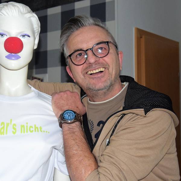Auf dem Foto ist Ingo Stromberg zu sehen. Er lehnt sich an eine Schaufensterpuppe an, die eine rote Pappnase trägt.