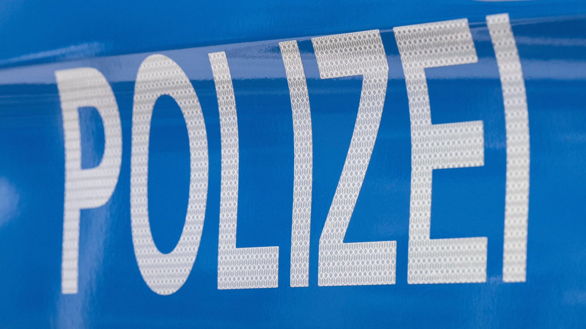 Der Schriftzug „Polizei“ ist auf einem Streifenwagen zu lesen.