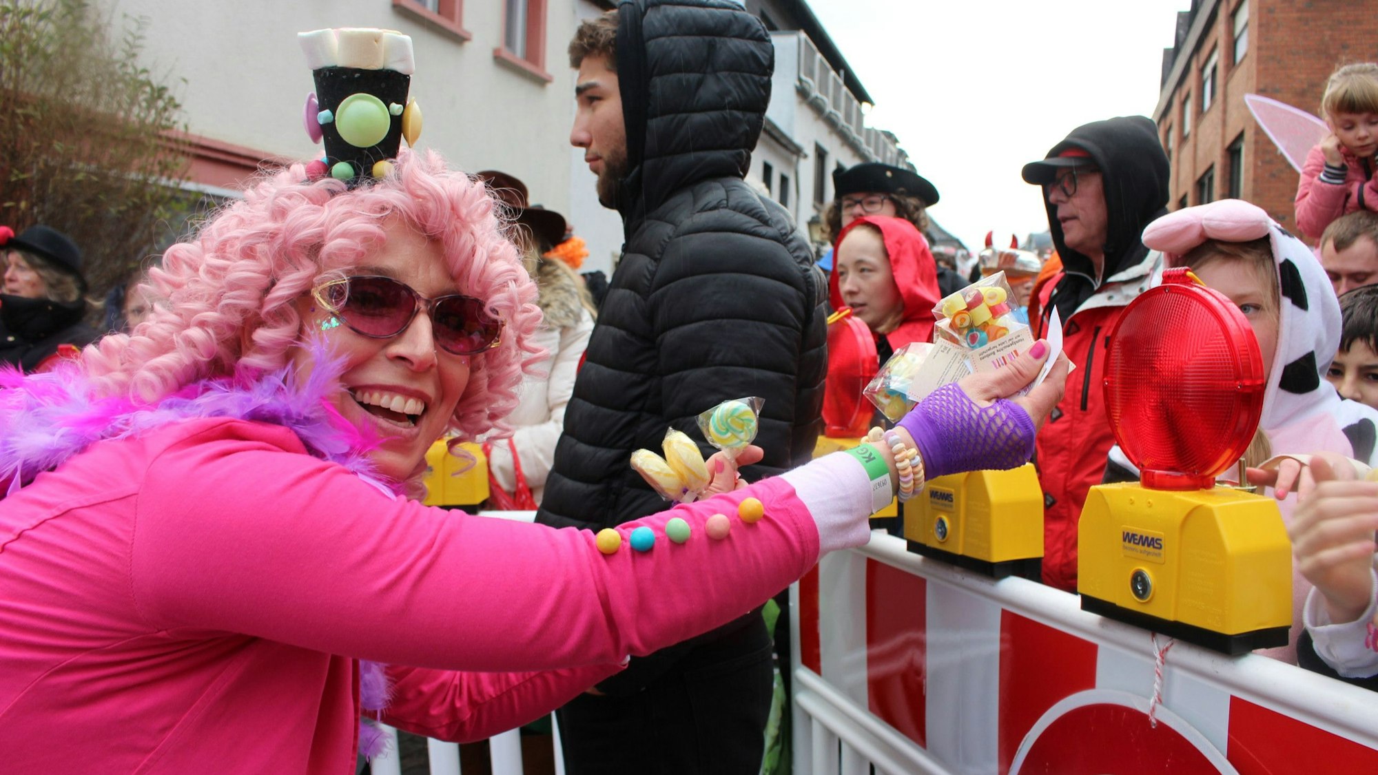 Das Bild zeigt den Kommerner Rosenmontagszug. Eine Teilnehmerin verteilt Kamelle an Kinder.