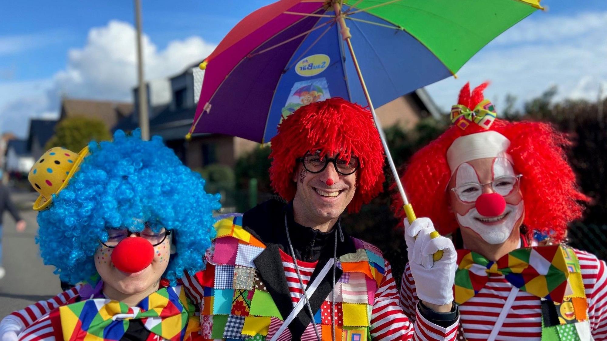 Auf dem Bild sind drei Clowns zu sehen.