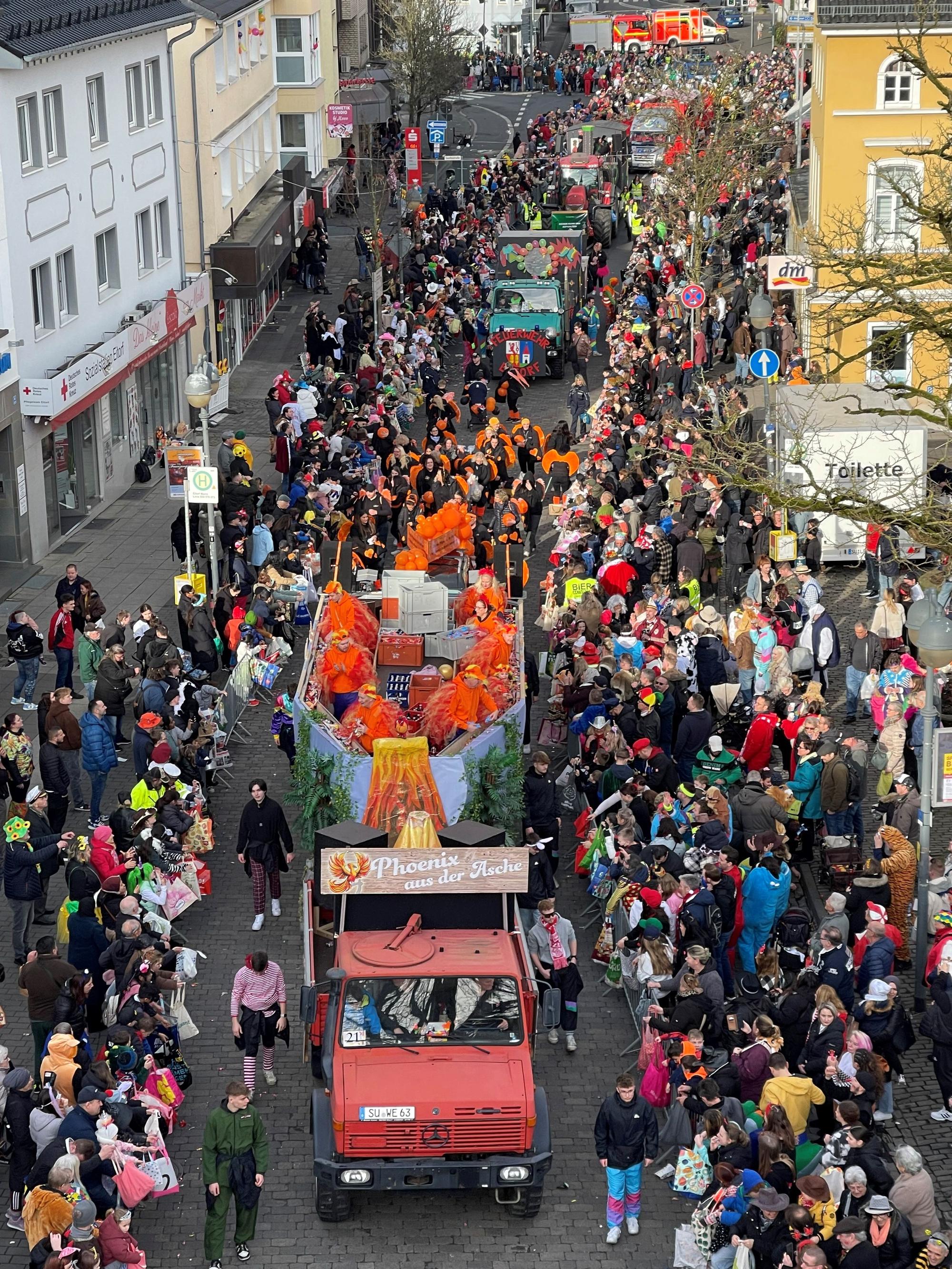 Ein Aufsichtsfoto des Eitorfer Rosenmontagszugs mit dem Wagen von Weco, der an hunderten Zuschauern vorbeifährt.