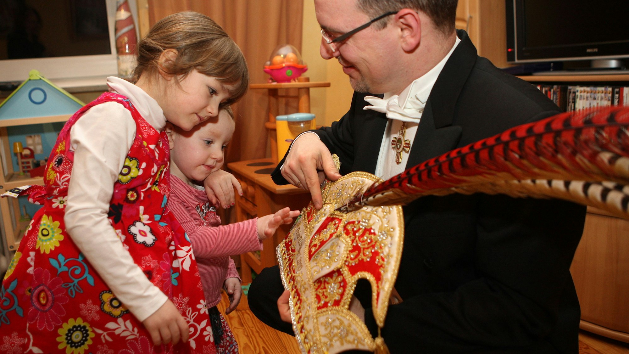 Alexander Pfister zeigt seinen Töchtern Marie und Magdalena im Jahr 2013 mit seine Prinzenkappe.