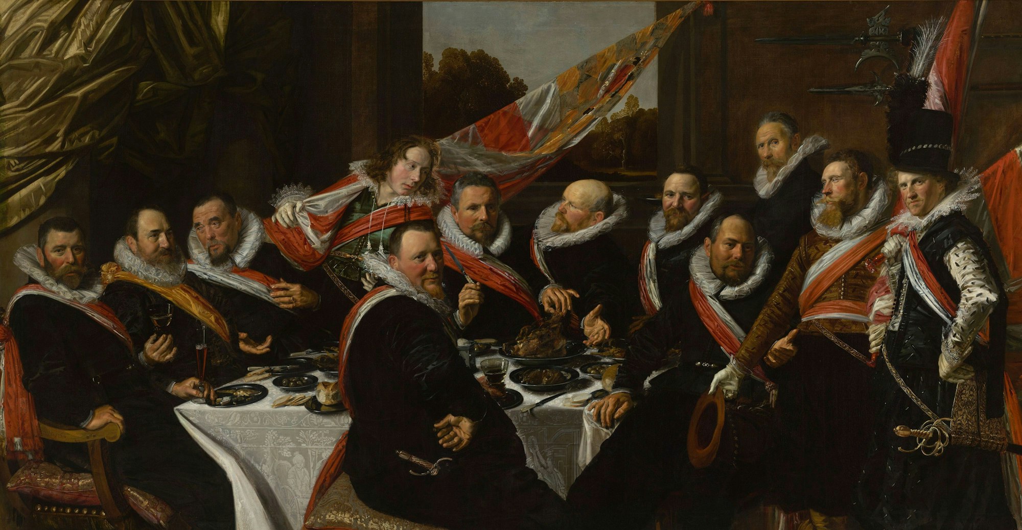 Eine Gruppe von Männern sitzt an einer reich gedeckten Tafel.