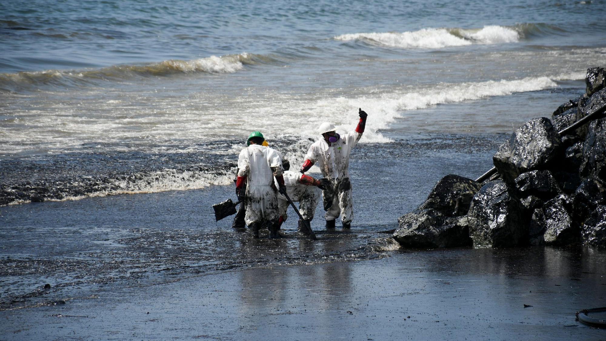 Arbeiter beseitigen einen Ölteppich, der den Strand von Rockly Bay in Scarborough im Südwesten Tobagos erreicht hat.