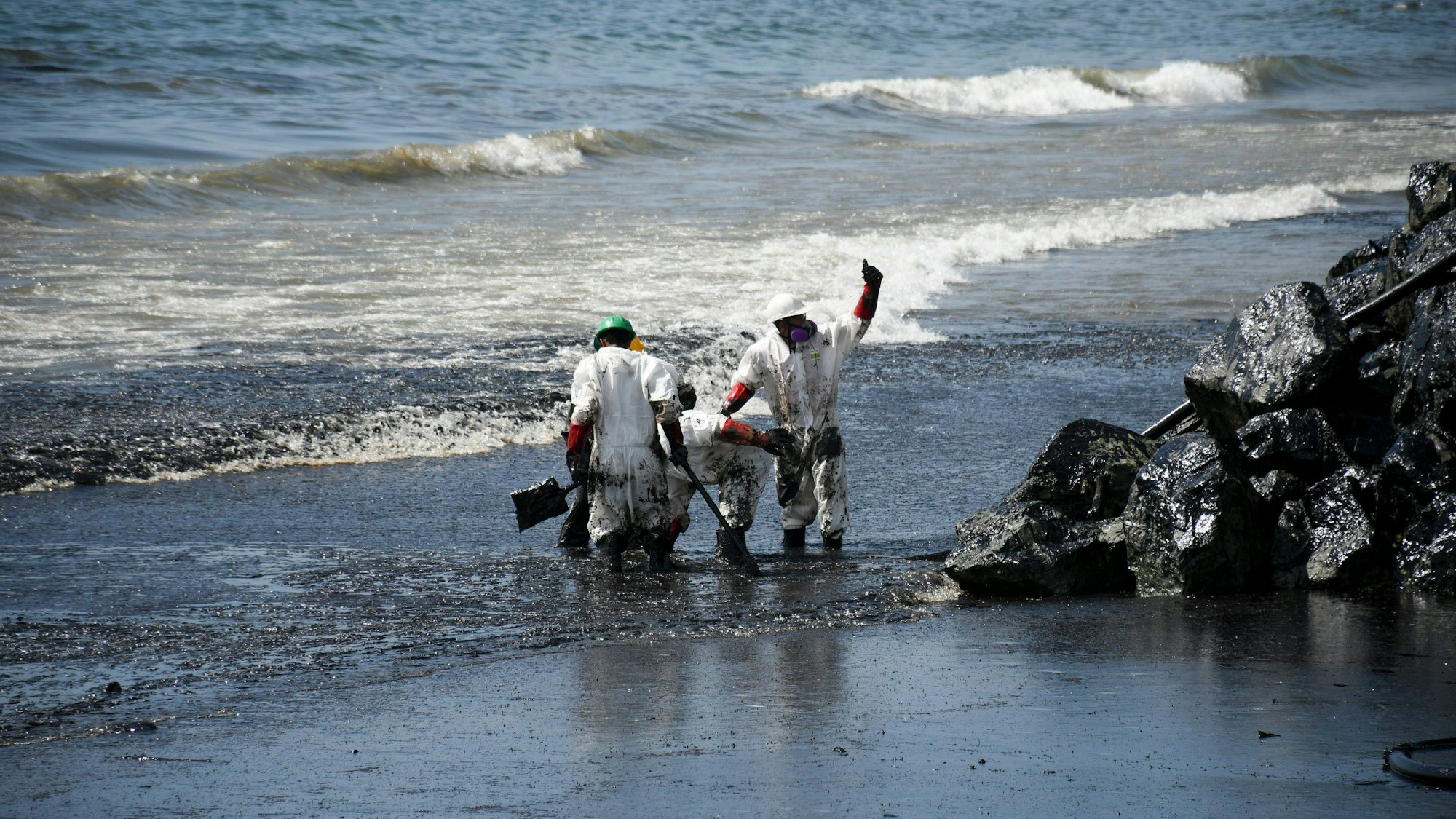 Arbeiter beseitigen einen Ölteppich, der den Strand von Rockly Bay in Scarborough im Südwesten Tobagos erreicht hat.