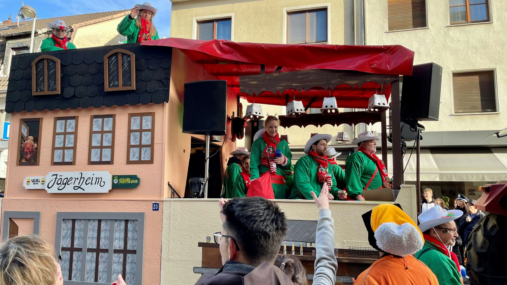 Ein Karnevalswagen, der aussieht wie eine Hausfassade und das Kneipenschild „Jägerheim“ trägt.