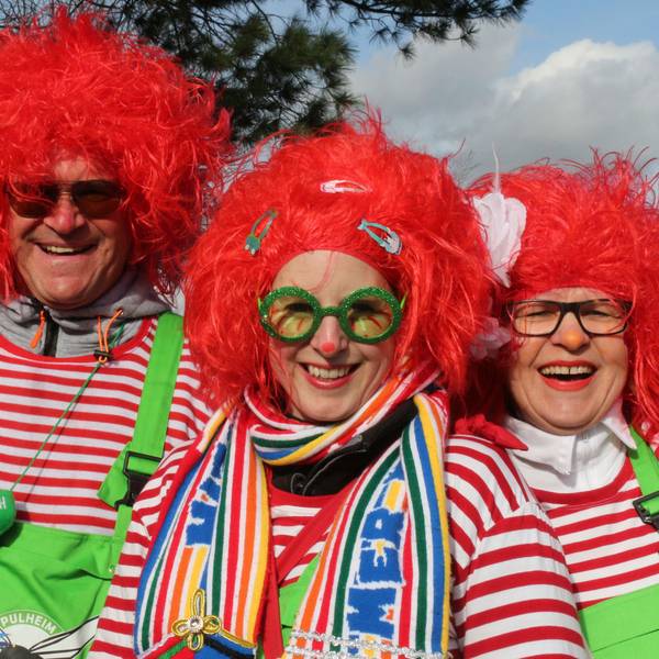 Rote Perücken, rot-weiß-gestreifte Shirts und grellgrüne Latzhosen tragen die drei jecken Handballer.