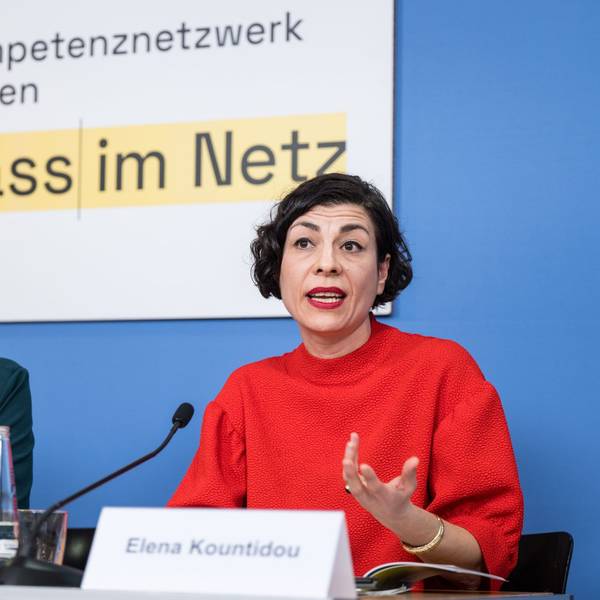Lisa Paus und Elena Kountidou sitzen an einem Tisch, vor ihnen stehen Namensschilder und Mikrofone auf dem Tisch. Im Hintergrund die Aufschrift "gegen Hass im Netz".