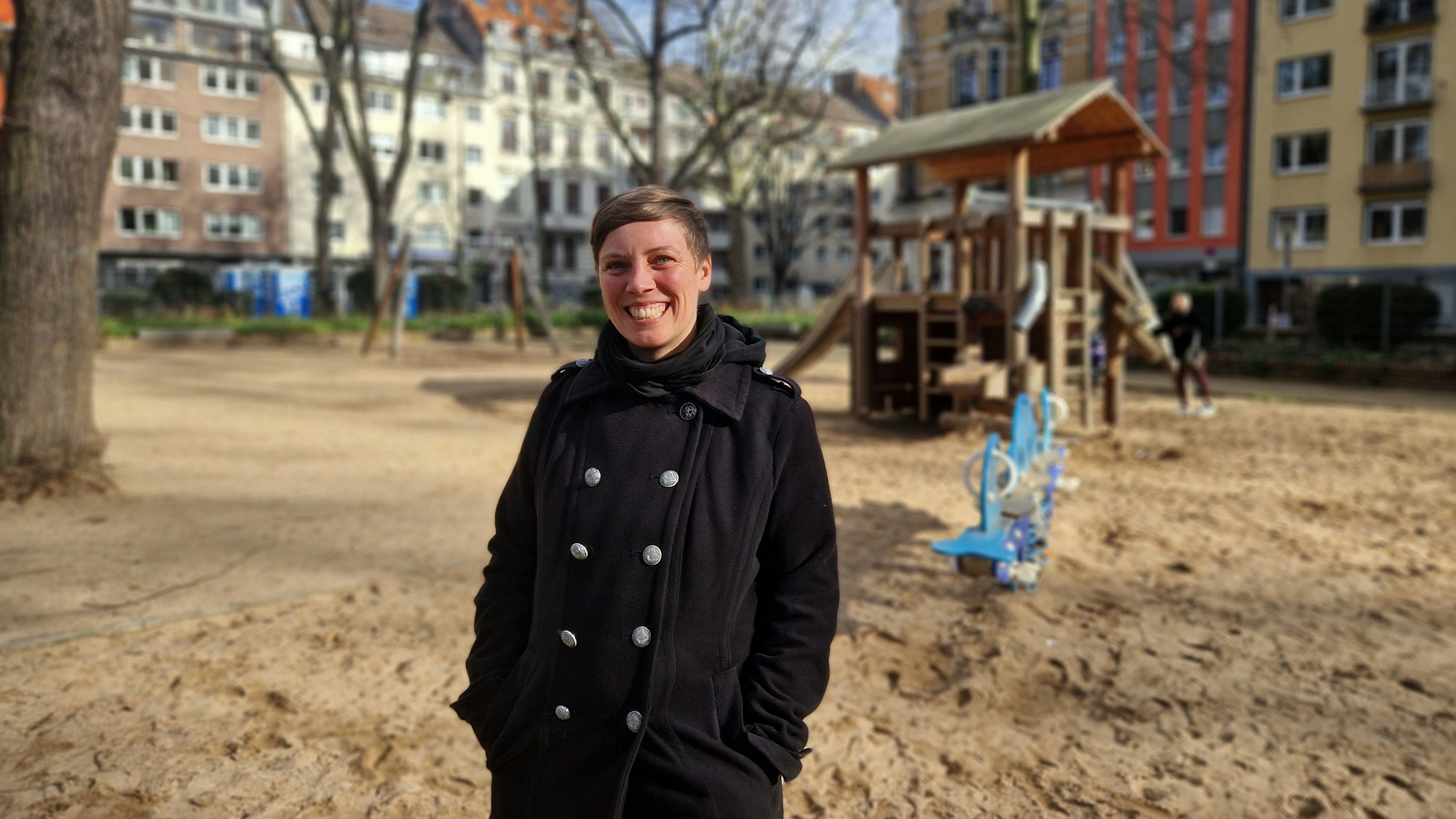 Eine Frau steht auf einem Spielplatz.