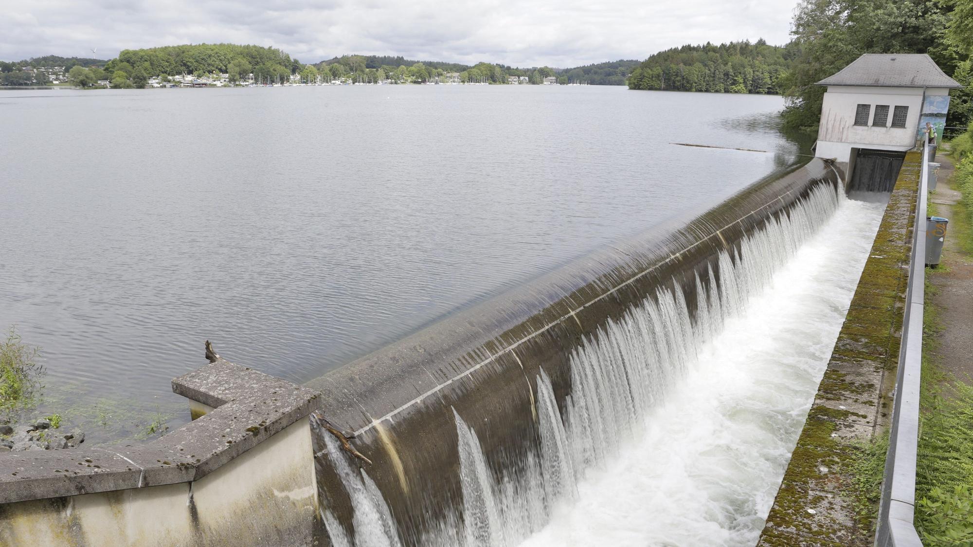 Wasseroberfläche einer Talsperre, Wasser läuft über eine Kante und stürzt in ein kleineres Becken.