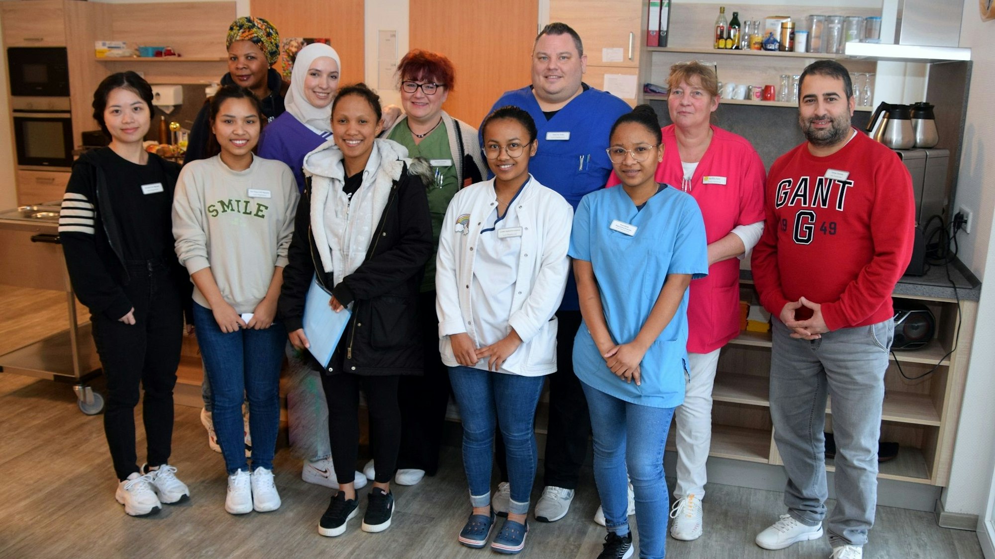 Pflege-Azubis und ihre Begleiter posieren zusammen für ein Foto.