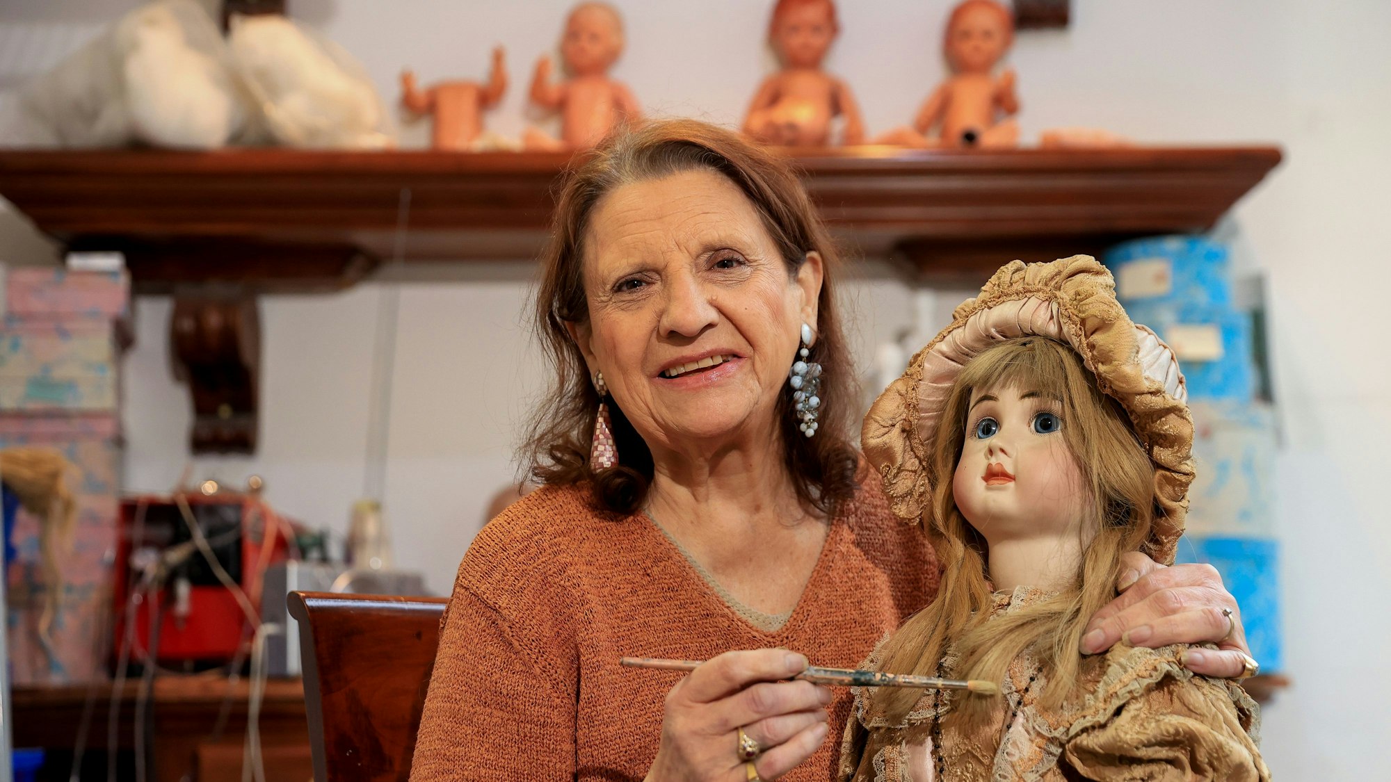 Joyce Merlet in ihrer Puppenklinik mit einer historischen Puppe