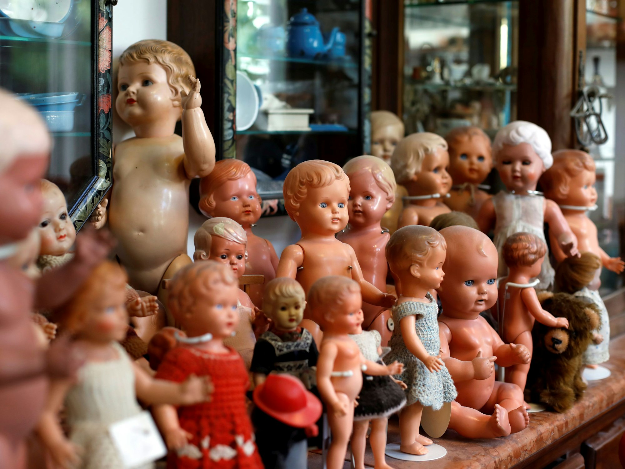 Historische Puppen stehen auf einer Vitrine.