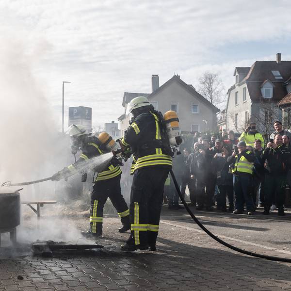 Baden-Württemberg, Biberach an der Riß: Einsatzkräfte der Feuerwehr löschen ein Feuer, das Demonstranten beim politischen Aschermittwoch der baden-württembergischen Grünen vor der Stadthalle von Biberach an der Riß angezündet haben. Die Veranstaltung wurde aufgrund der Proteste vor der Stadthalle abgesagt.