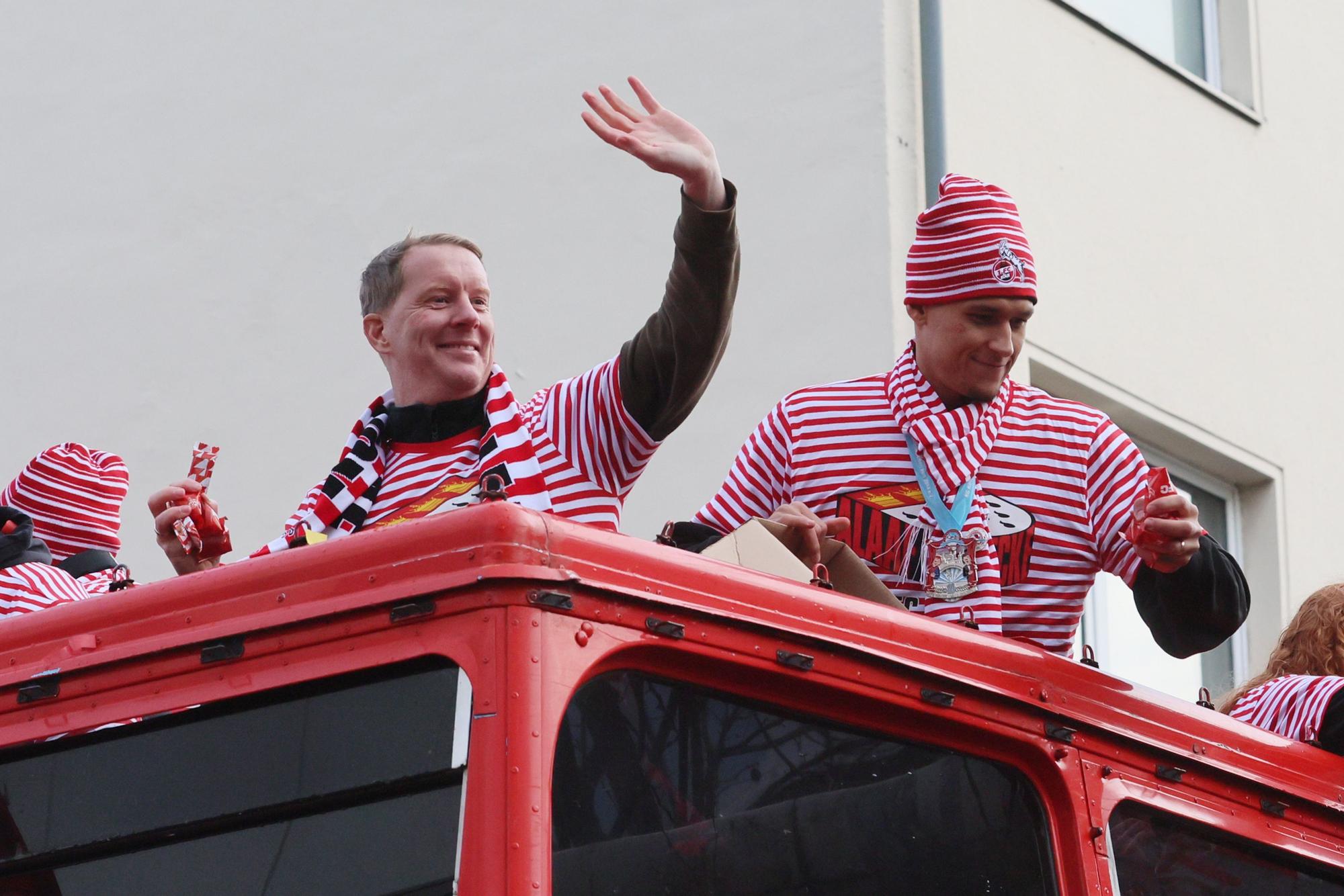 Kölns Trainer Timo Schultz und Stürmer Davie Selke (r.) grüßen vom Wagen des 1. FC Köln beim Rosenmontagszug.