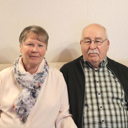 Ein Mann und eine Frau sitzen auf einem Sofa.