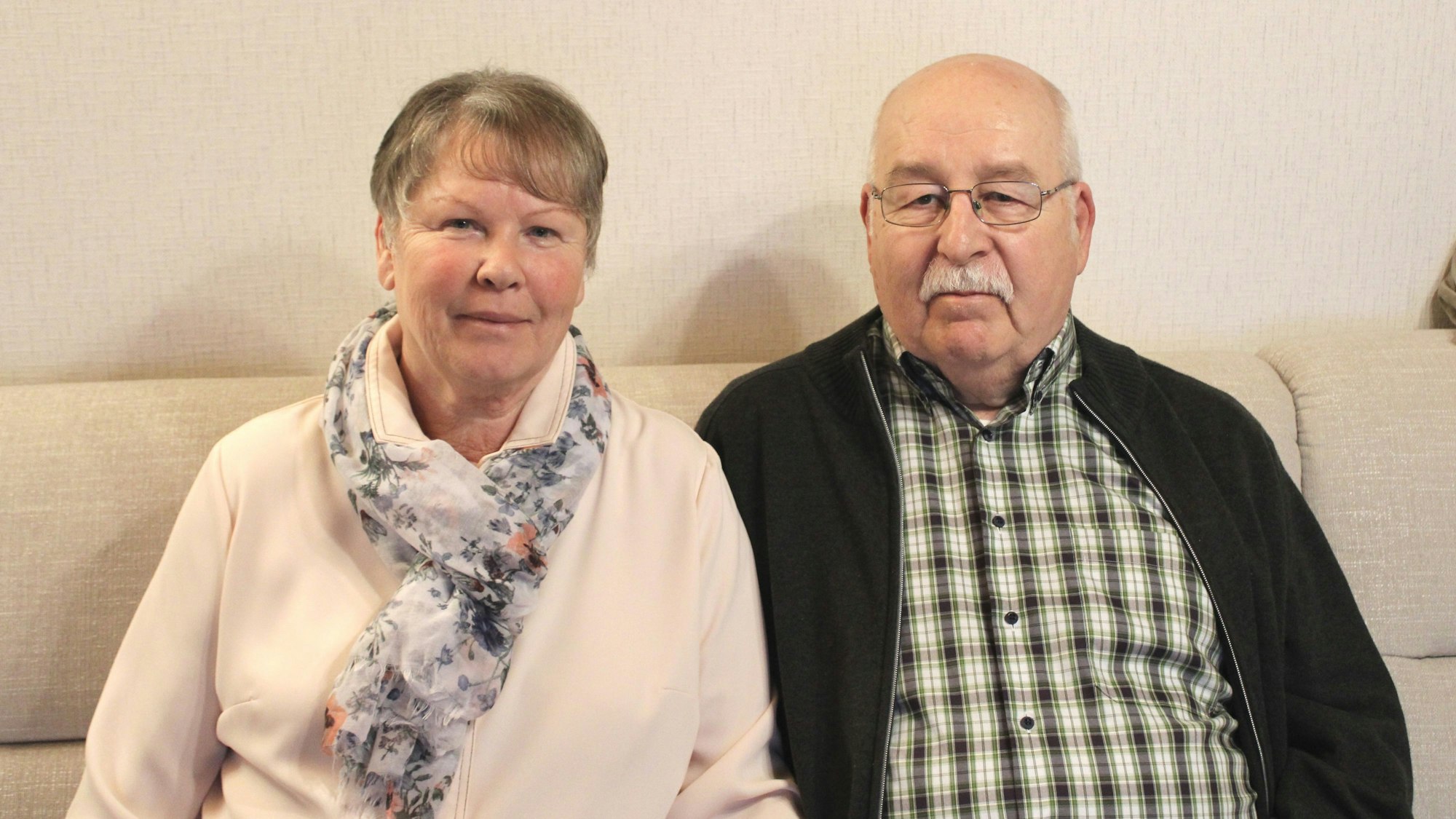 Ein Mann und eine Frau sitzen auf einem Sofa.