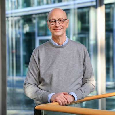 Porträt eines Mannes mit Brille, Glatze und grauem Pullover