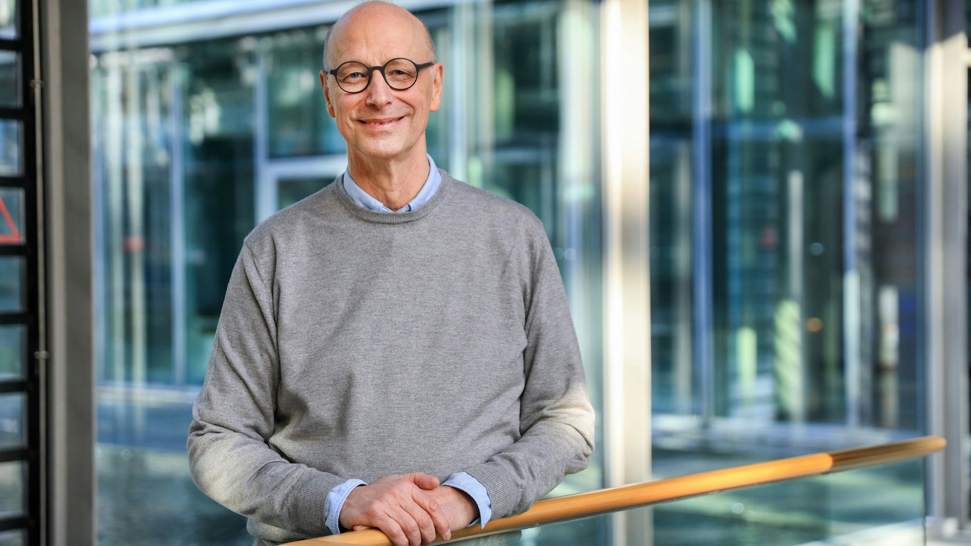 Porträt eines Mannes mit Brille, Glatze und grauem Pullover