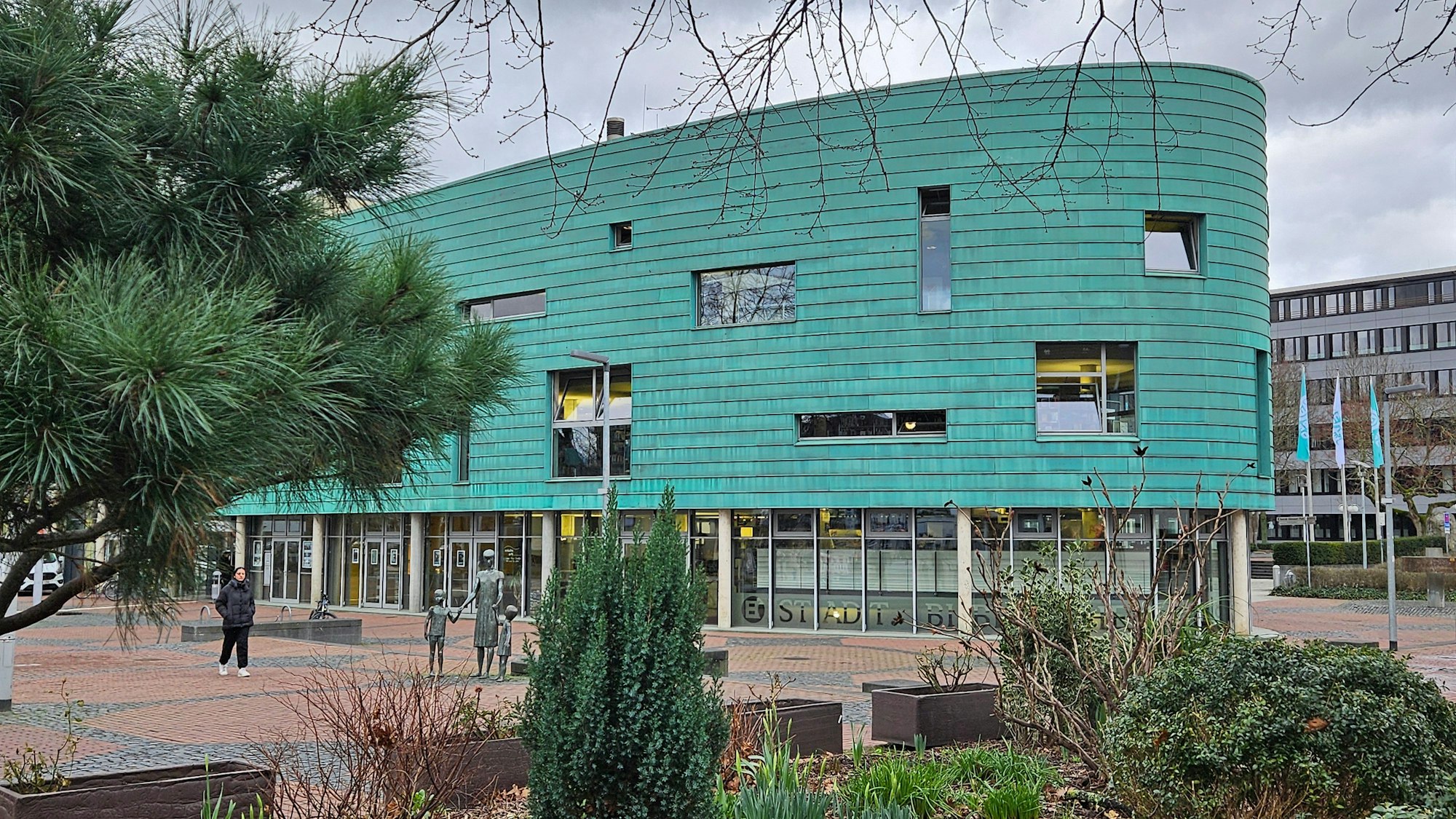 Ein großes Gebäude in der Form eines Schiffbugs mit grüner Fassade.