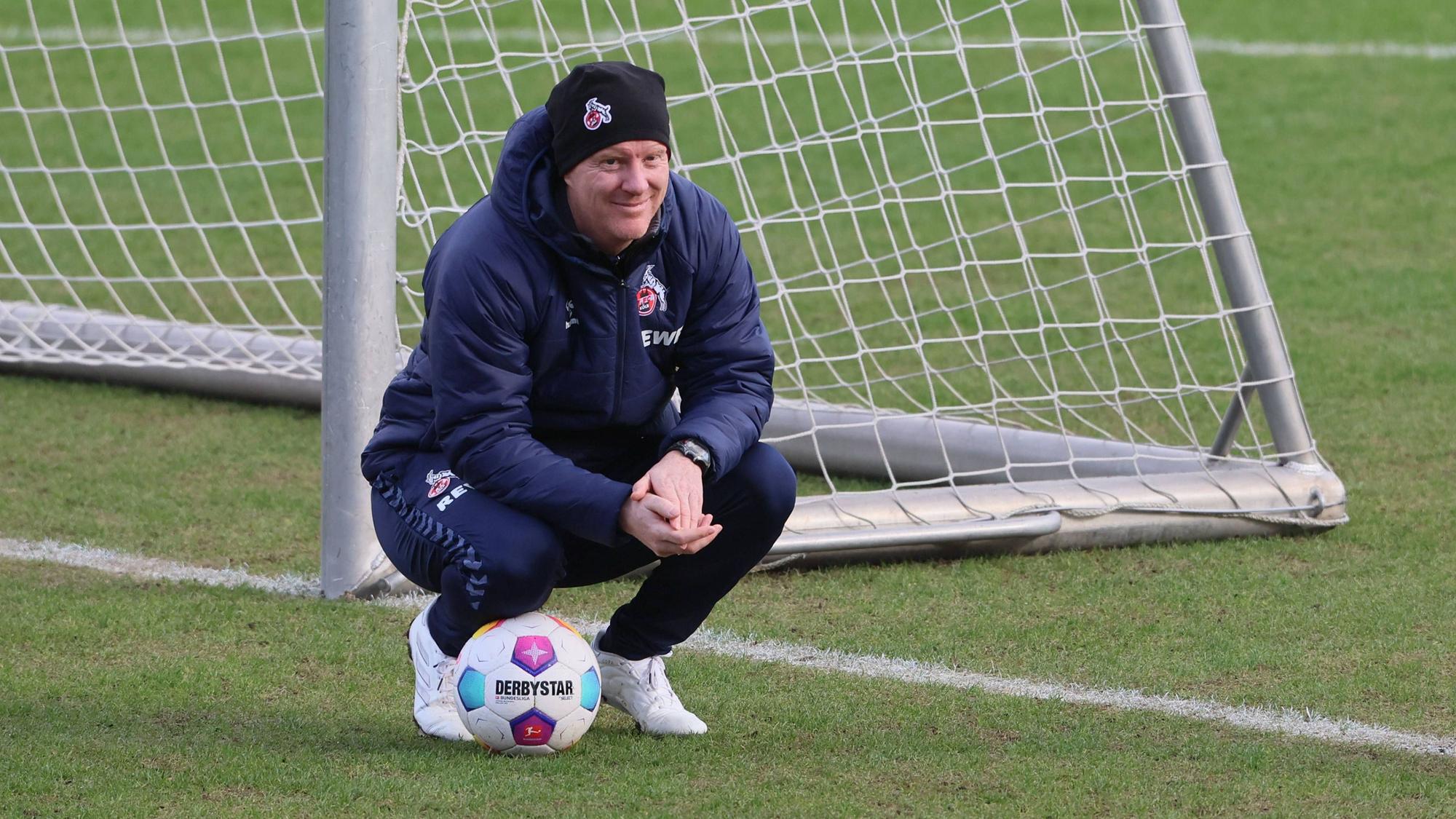 Kölns Trainer Timo Schultz geht beim Training in die Hocke.