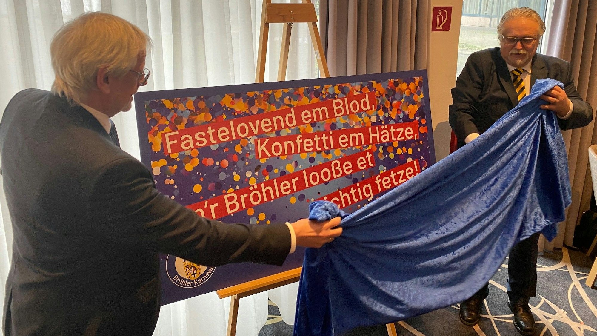 Zu sehen sind Festausschuss-Präsident Peter Lautenschläger und Bürgermeister Dieter Freytag beim Enthüllen eines Plakats.