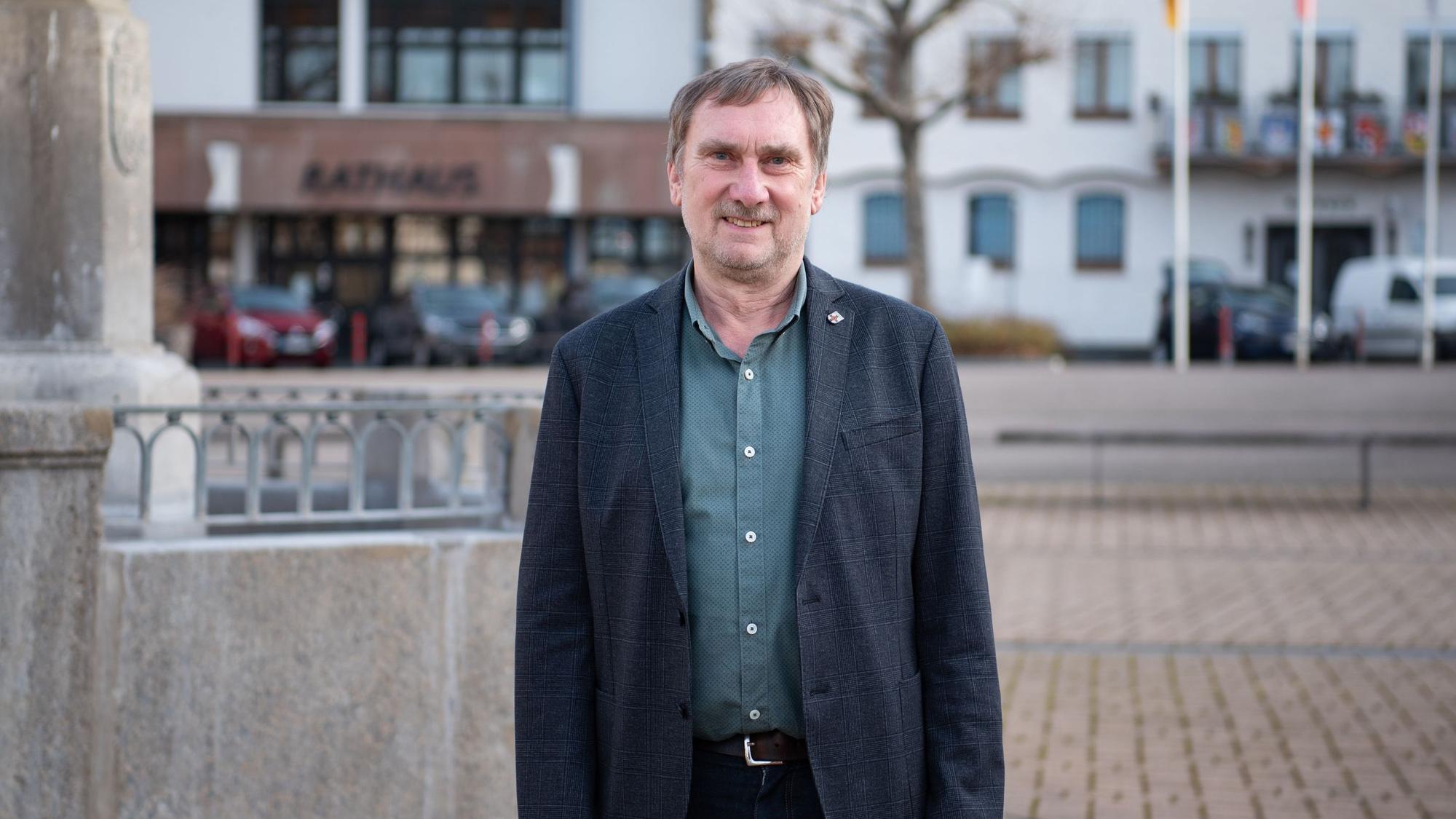 Ottmar Voigt, Kämmerer und Erster Beigeordneter der Stadt Zülpich, steht auf dem Marktplatz vor dem Rathaus.
