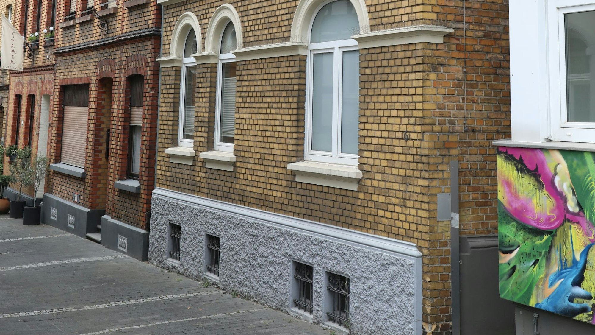 Zwei Gebäude mit gelber und roter Ziegelsteinfassade.