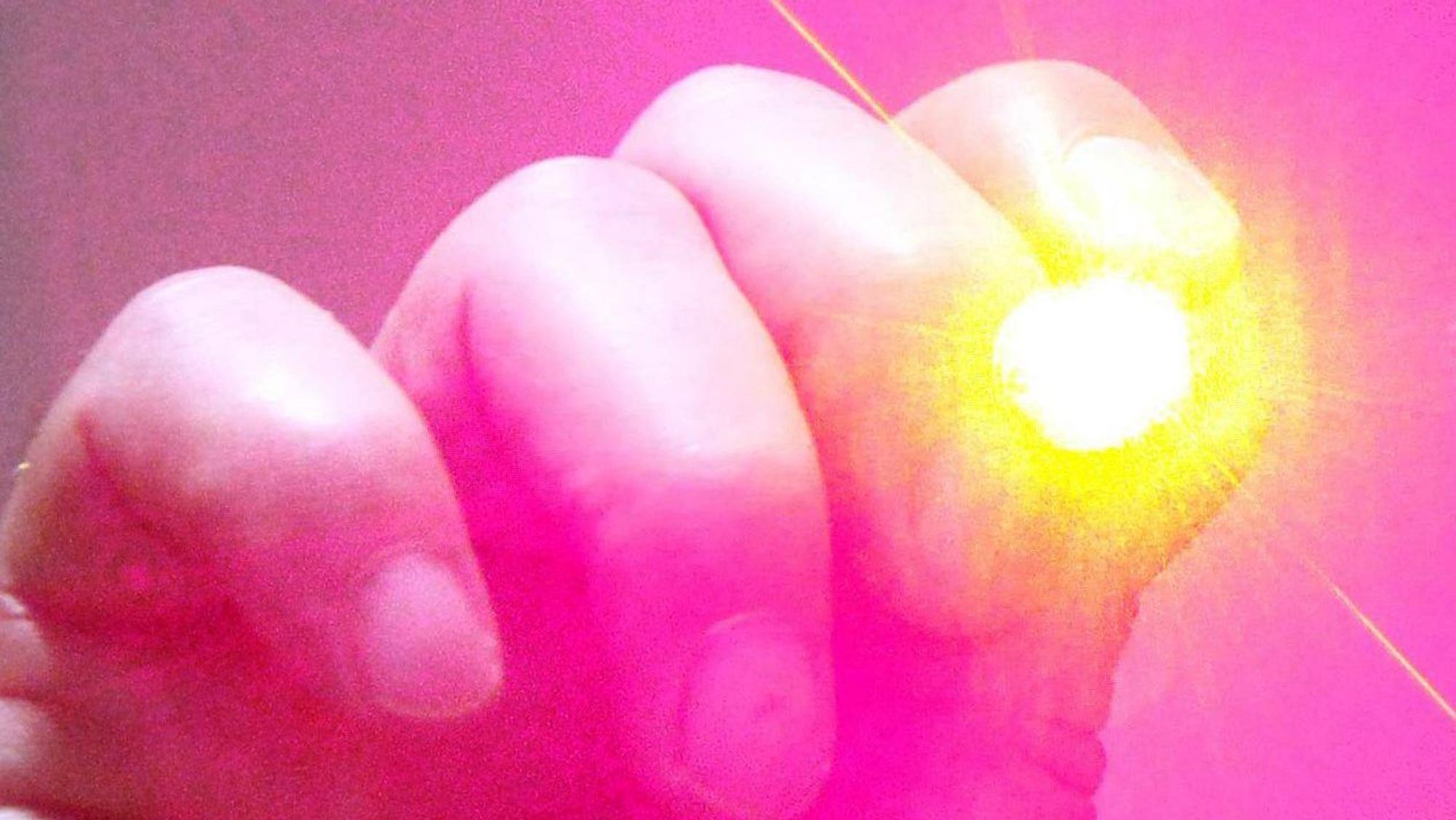 Auf dem Foto ist eine Hand zu sehen, die einen Laserpointer hält.