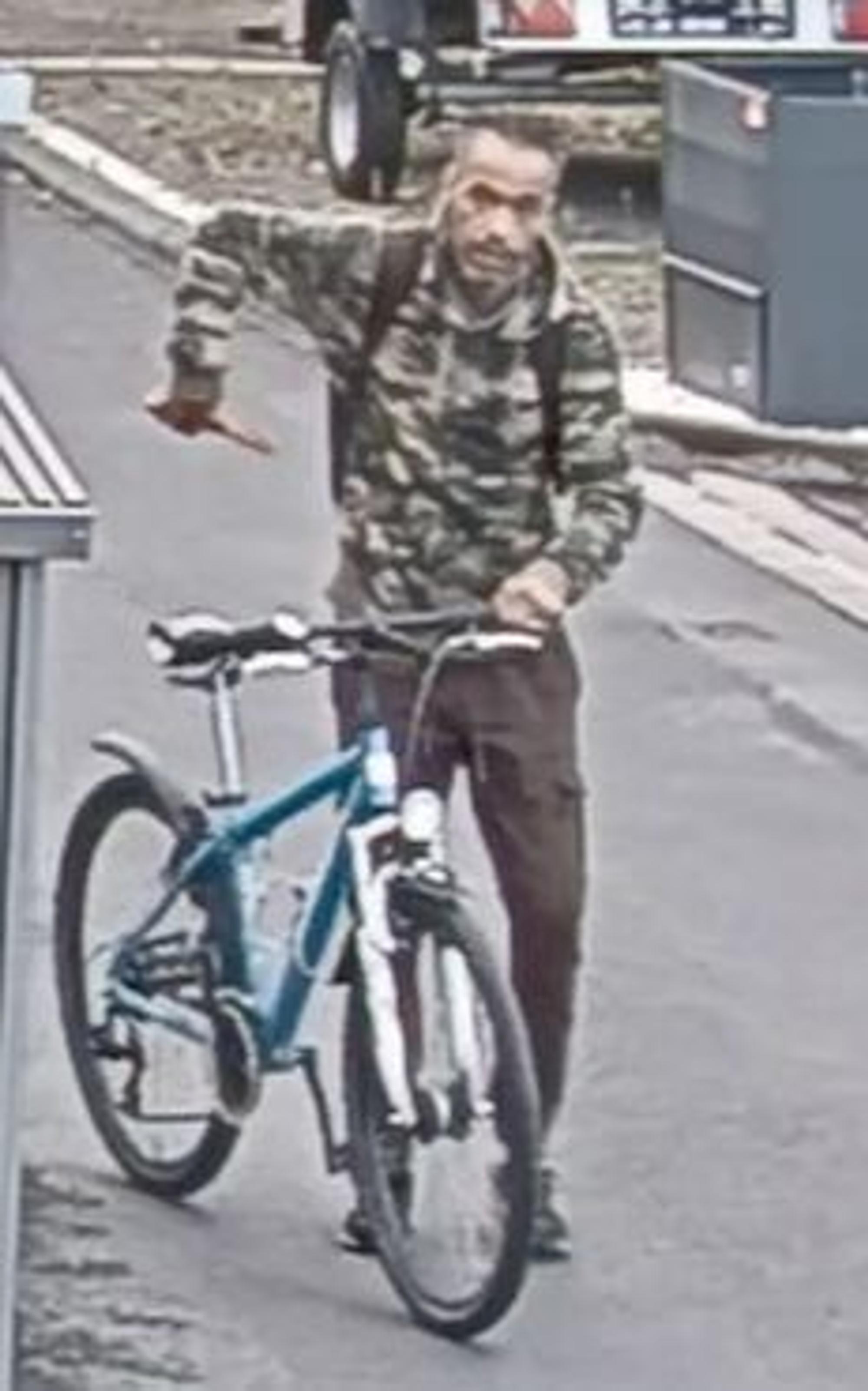 Die Aufnahme der Überwachungskamera zeigt den tatverdächtigen Mann in Bonn mit einem Fahrrad