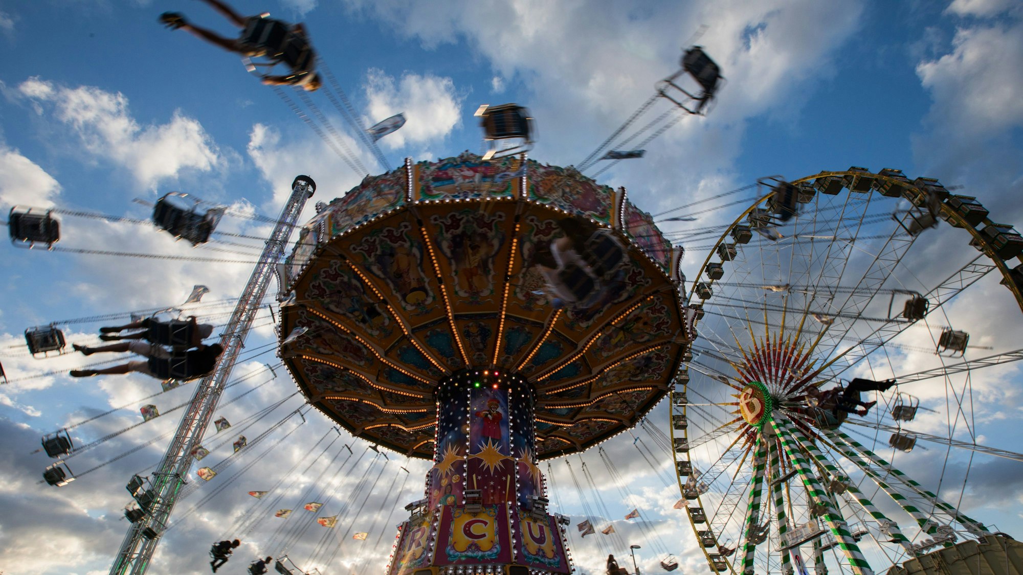 Ein Kettenkarussell dreht sich auf einer Kirmes im Licht der untergehenden Sonne. (Symbolbild)