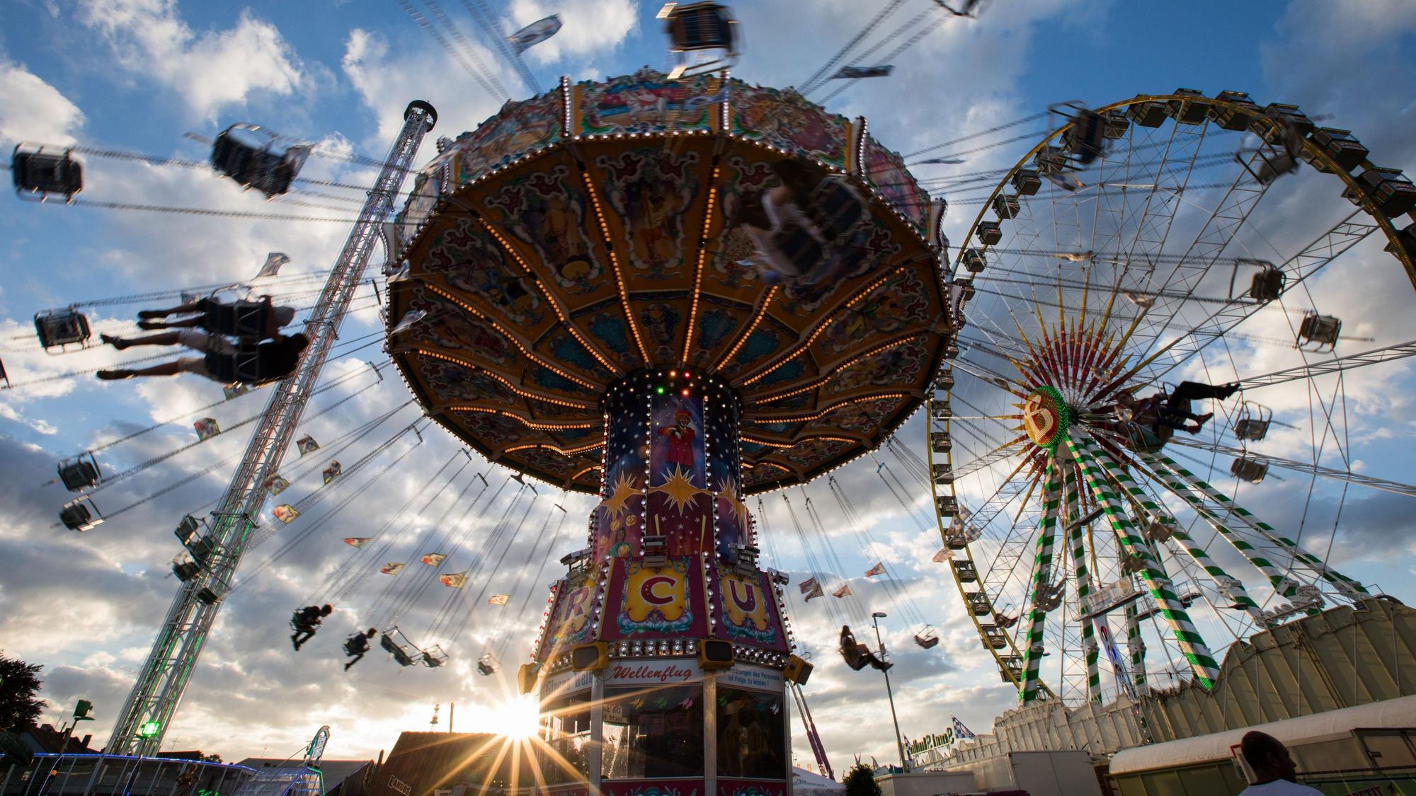 Ein Kettenkarussell dreht sich auf der Cranger Kirmes im Licht der untergehenden Sonne