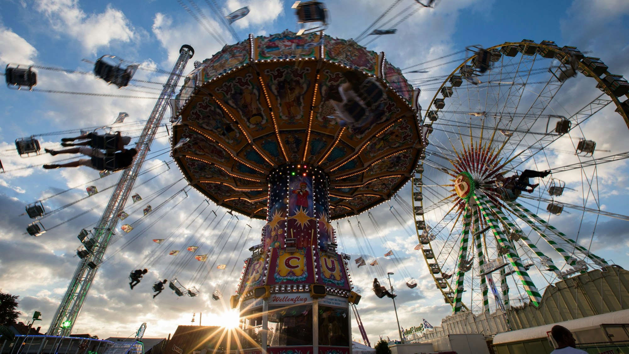 Ein Kettenkarussell dreht sich auf der Cranger Kirmes im Licht der untergehenden Sonne