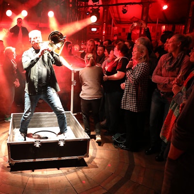 Clemens Tewinkel an der Posaune beim besonderen Auftritt aus einer Technikkiste, deren Deckel gerade abgenommen worden ist.