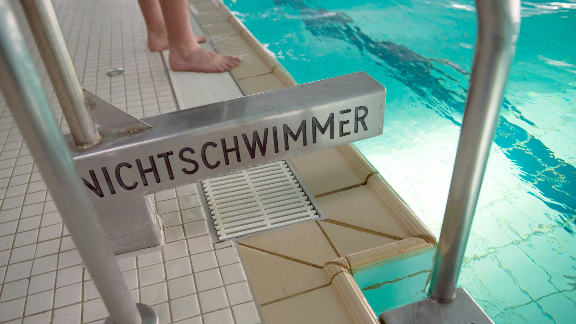 Eine Leiter führt in ein Schwimmbecken, darauf steht der Aufdruck „Nichtschwimmer“.