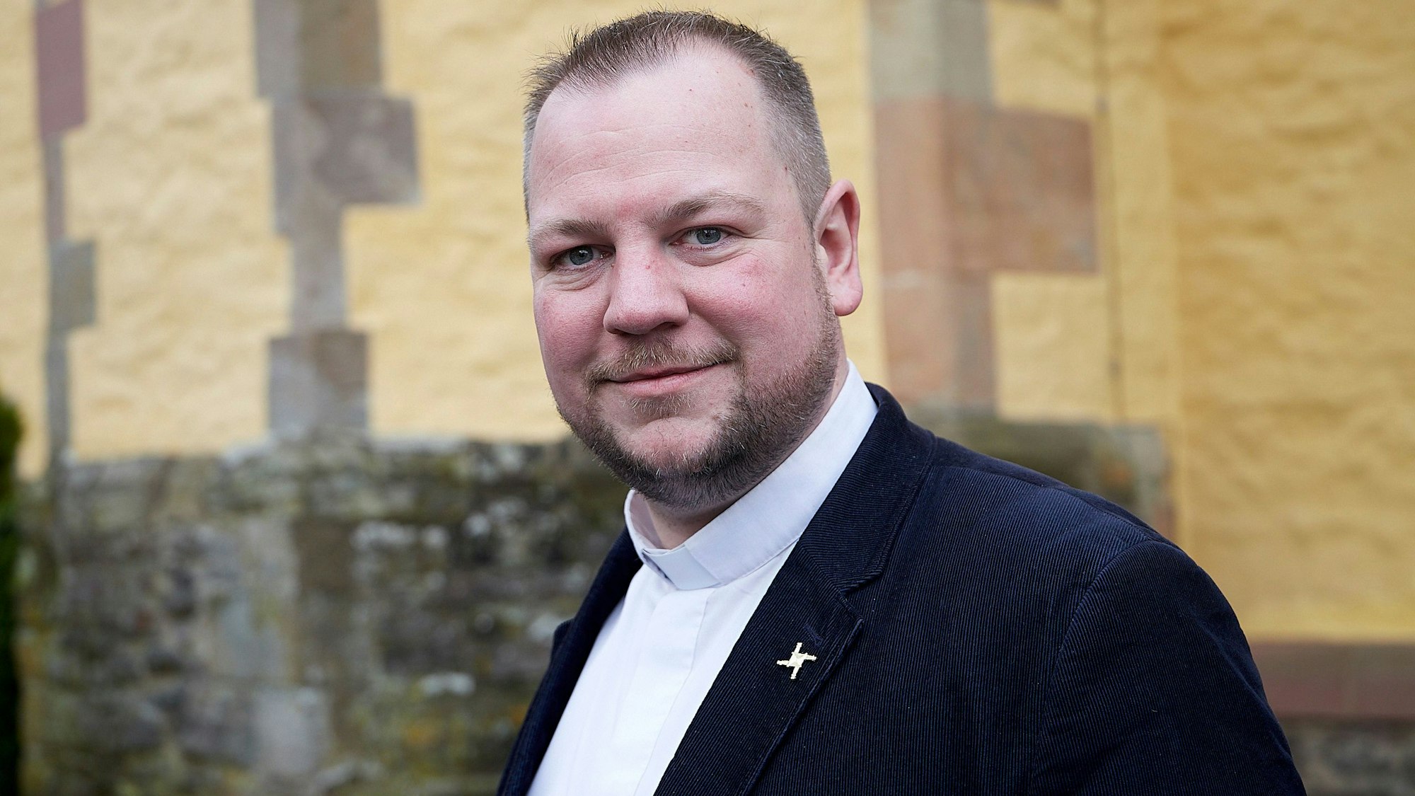 Der Leiter der GdG Schleiden/Hellenthal, Pastor Thomas Schlütter, steht vor der Schlosskirche in Schleiden.