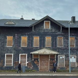 Das Bahnhofsgebäude in Blankenheim-Wald steht seit 15 Jahren leer. Die Fenster des Hauses mit der Schiefer-Fassade sind mit Holzbrettern verschlossen.